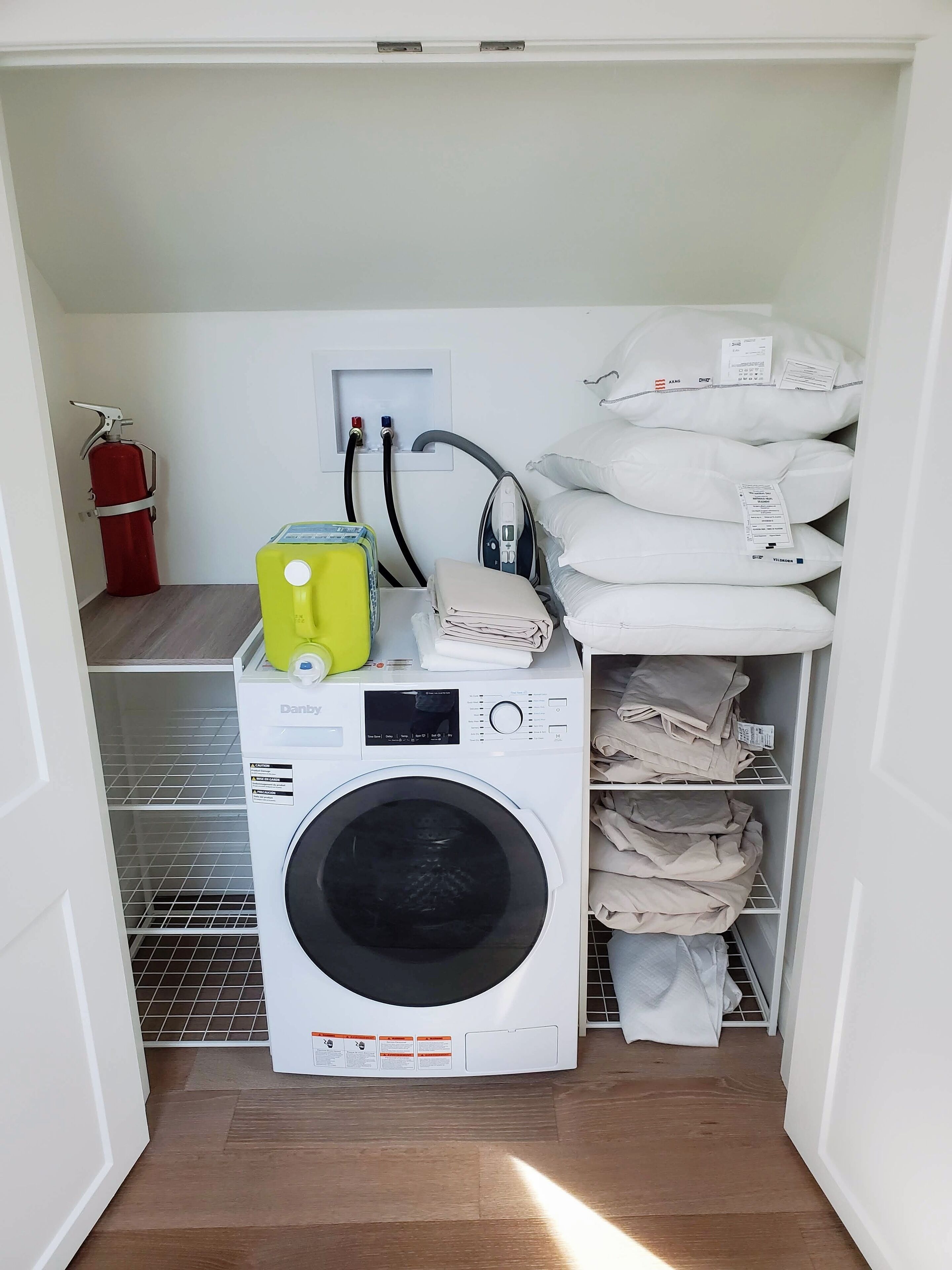 A laundry room with a washing machine, a dryer, and a fire extinguisher.