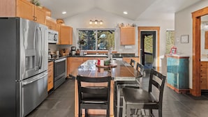 A modern kitchen with wooden cabinets, stainless steel appliances, and a large island with seating.