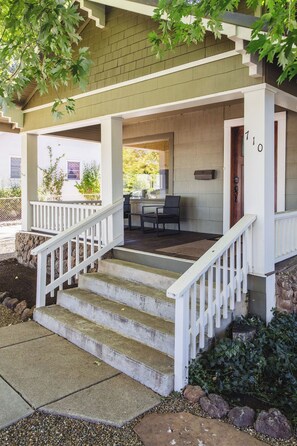 A covered porch with a set of concrete steps leading to a door marked with the number 710.