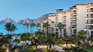 A resort with multiple-story buildings, a pool area, palm trees, and a mountainous backdrop. -  Villa La Estancia 1509 Premium Ocean View! (Cabo san Lucas)