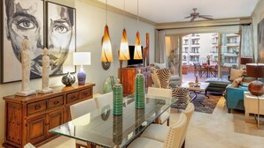 A modern living room with a glass dining table, a sofa, and a balcony with a view of the city. -  Villa La Estancia 1509 Premium Ocean View! (Cabo san Lucas)