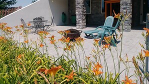 A patio area with outdoor furniture, a stone pillar, and a view of the house's exterior. - Spacious Quiet Country Home With Stunning Views from Private Patio (Inkom)
