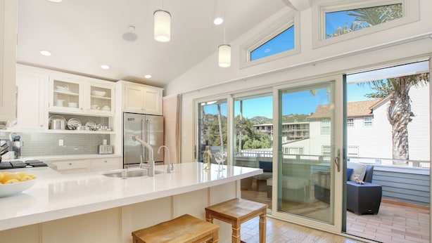 A modern kitchen with a large island, white cabinetry, and a view of the outdoors. - Sunsetter in Avila Beach - 2 min walk to beach, located in Ocean 17 (Avila Beach)