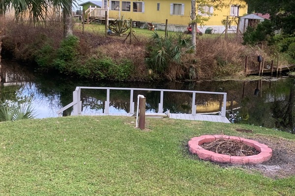 Fire pit on corner of lot near dock at intersecting canals.