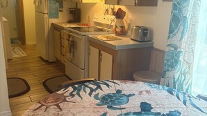 Een kleine keuken met een koelkast, fornuis en broodrooster.