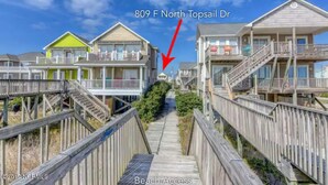 A beachfront property with wooden boardwalks leading to multiple houses, labeled as 809 F North Topsail Dr. - Your Perfect Beach House (Surf City)