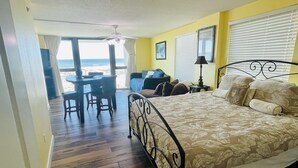 A bedroom with a bed, a desk, and a chair. There is a window with blinds and a view of the beach. - 2bd2 1/2ba sleeps8 1st&2fltownhouse onbeachw/dolphin views,boating,tennis,fishin (Pensacola)