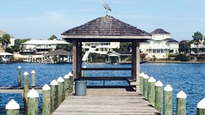 A wooden pier leading to a gazebo with a tiled roof, surrounded by water and houses in the background. - 2bd2 1/2ba sleeps8 1st&2fltownhouse onbeachw/dolphin views,boating,tennis,fishin (Pensacola)
