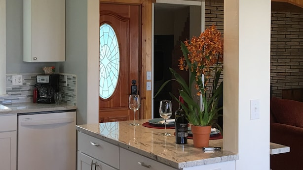 A kitchen with a marble countertop, a potted plant, wine glasses, and a bottle of wine. - NEW! Tranquil Oceanfront Gem with Hot-tub 3 BDRM + Den, 3 BATH (Waldport)