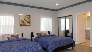 A bedroom with two beds, a large mirror, and a door leading to a bathroom. - * Living Large * Newly Built * Disneyland & Beaches (Midway City)
