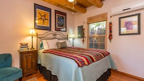 A bedroom with a bed, two bedside tables, a chair, and a window. - Favorite Downtown Adorable Adobe ~ 10 min walk to Plaza (Santa Fe)