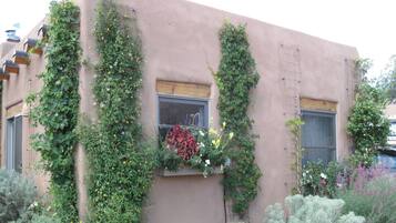 Un edificio con jardines verticales y una ventana con flores.