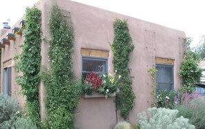 Un edificio con jardines verticales y una ventana con flores.