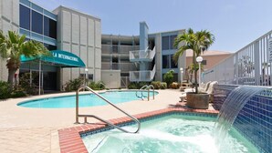 Un hôtel doté d’une piscine, d’un espace couvert et d’un bâtiment avec des balcons.