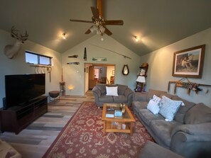 Relax in this stylish living room with a large flat-screen TV, comfortable sofas, and a warm ambiance.