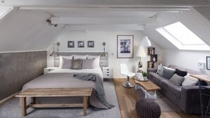 A modern loft bedroom with a large bed, a desk, and a sofa. - Charming Modern cosy Cottage -50m2- (Bourbourg)