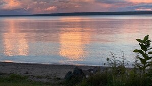 Un lago tranquilo con cielo despejado y algunas nubes.