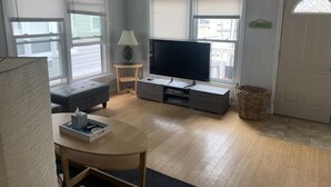 A living room with a TV, sofa, and a lamp.