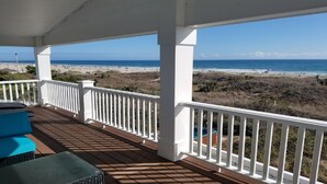 Eine überdachte Terrasse mit Blick auf Strand und Meer.