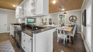 Una cocina amplia con armarios blancos, encimera de granito y una isla grande.
