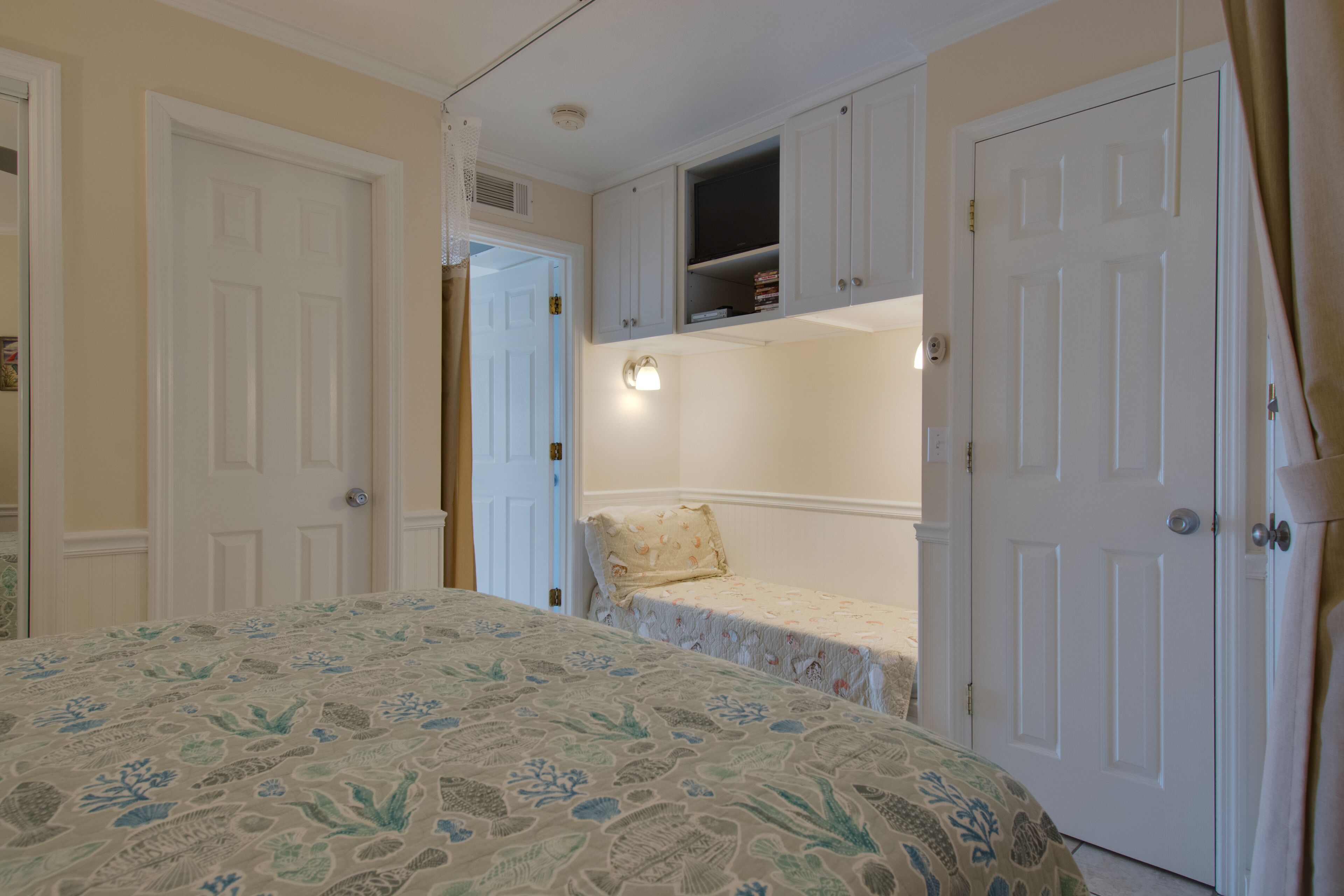 A bedroom with a bed, a closet, and a small shelf unit.