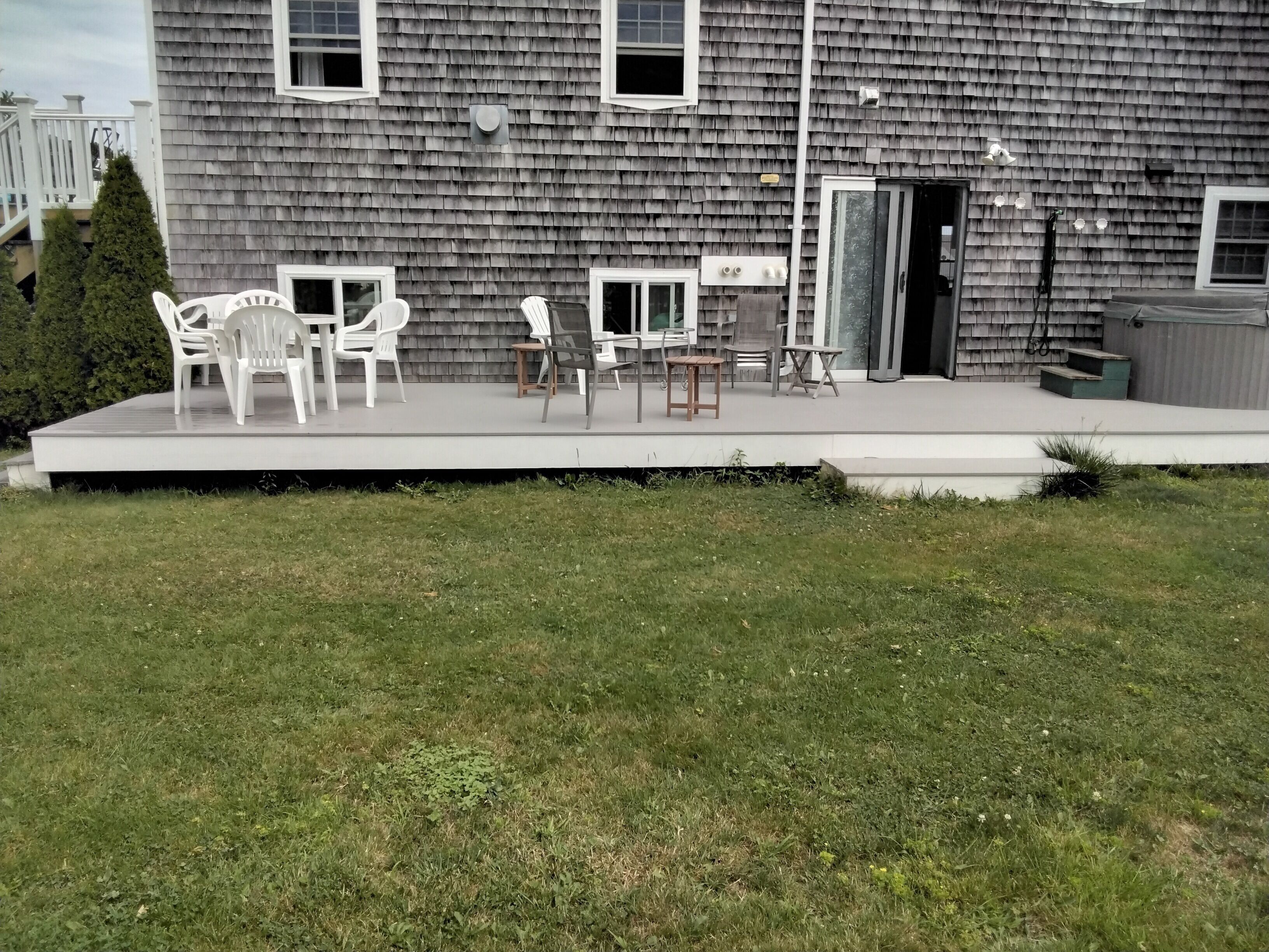 A building with a covered patio area featuring outdoor furniture.