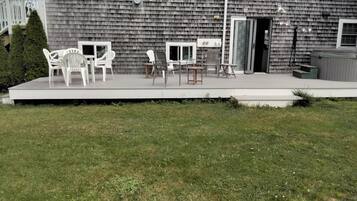 A building with a covered patio area featuring outdoor furniture.