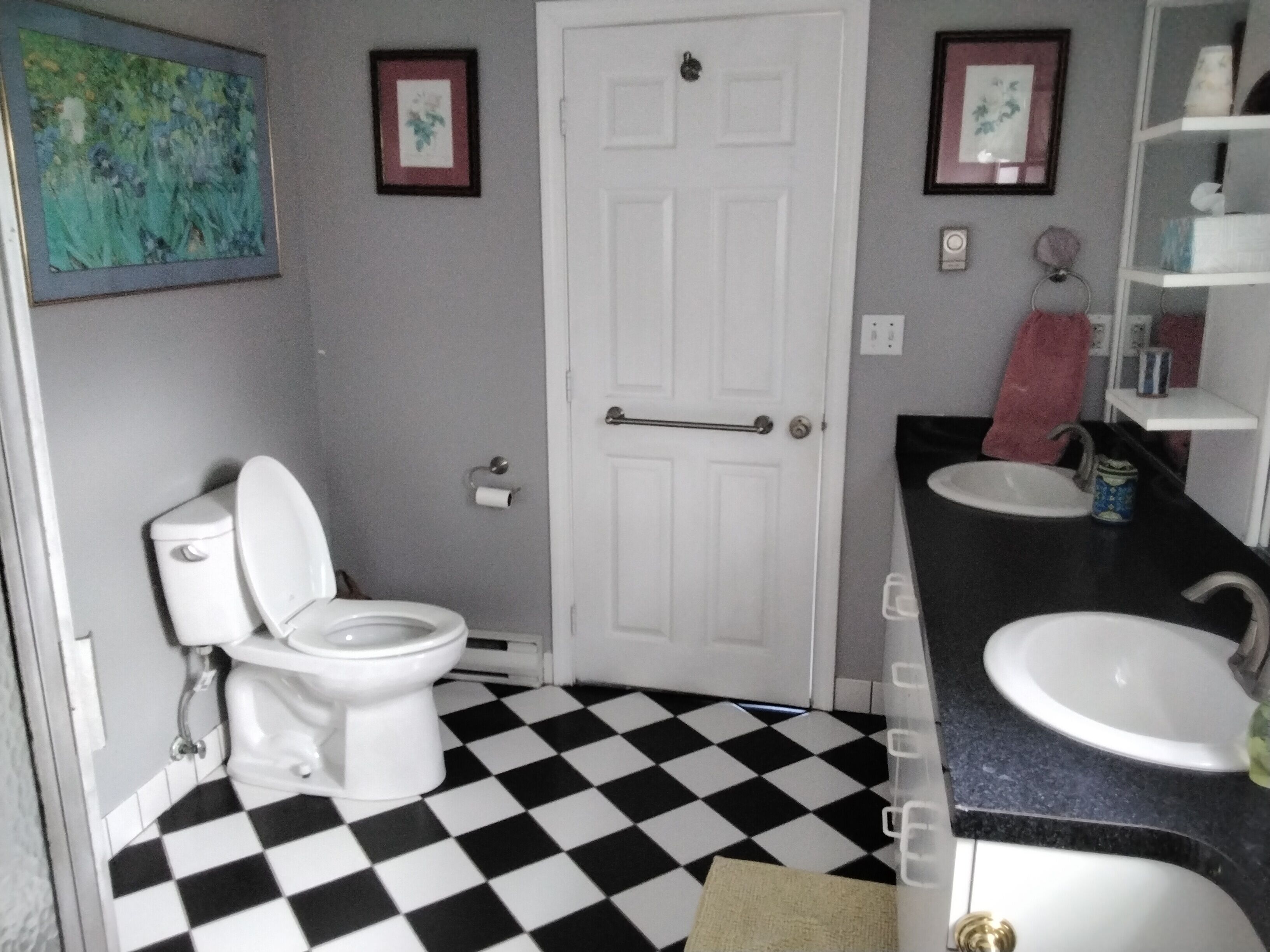 Ein Badezimmer mit Toilette, Waschbecken und einem Schachbrettmuster-Boden.