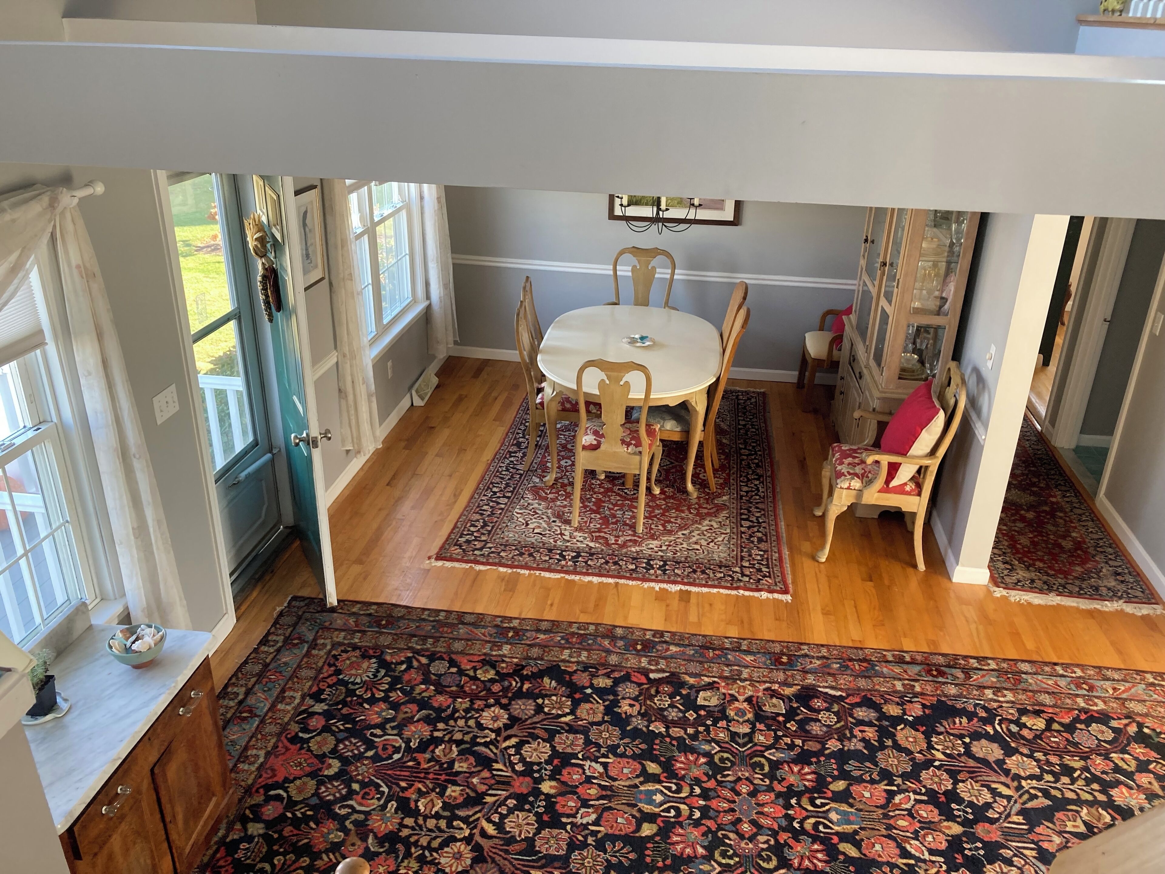 A dining area with a round table, chairs, and a patterned rug.