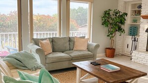 A living room with a sofa, a coffee table, and a potted plant.