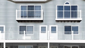 A two-story building with a balcony, stone facade, and multiple windows. - PERFECT, BEAUTIFULLY NEWLY DESIGNED 1,000 FT. MONTAUK OCEANFRT 3-LEVEL TOWNHOUSE (Montauk)