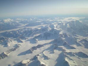 A panoramic view of snow-covered mountain peaks from an aerial perspective. - Near Anchorage Airport, Lake Hood and the Cook Inlet Coast (Anchorage)