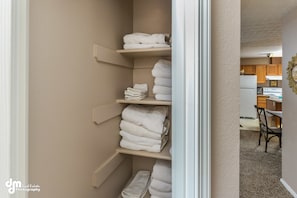 Storage space with multiple shelves and a kitchen area.