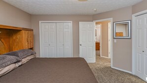 Un dormitorio con cama, armario y puerta que da a otra habitación.