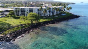 A beachfront hotel with multiple floors, a pool area, and a view of the ocean.