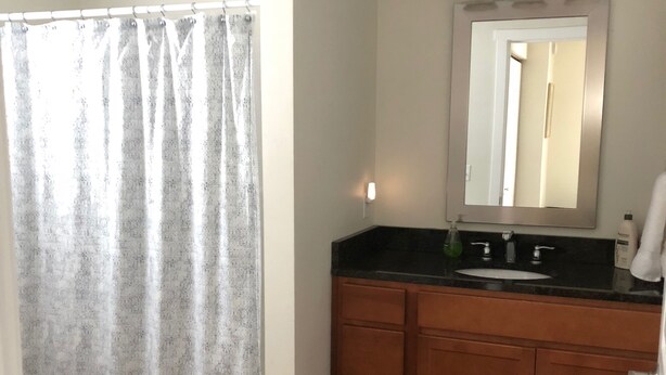 Un baño con armarios de madera, un lavamanos y un espejo.