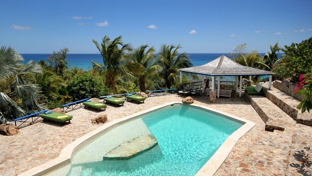 A pool with clear water, surrounded by lounge chairs and a gazebo. - The Carib House, Turtle Bay 5 room villa, pool, views, beach, English Harbour no (St Paul)