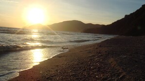 A beach with the sun setting over the ocean, casting a warm glow on the water and sand. - The Carib House, Turtle Bay 5 room villa, pool, views, beach, English Harbour no (St Paul)