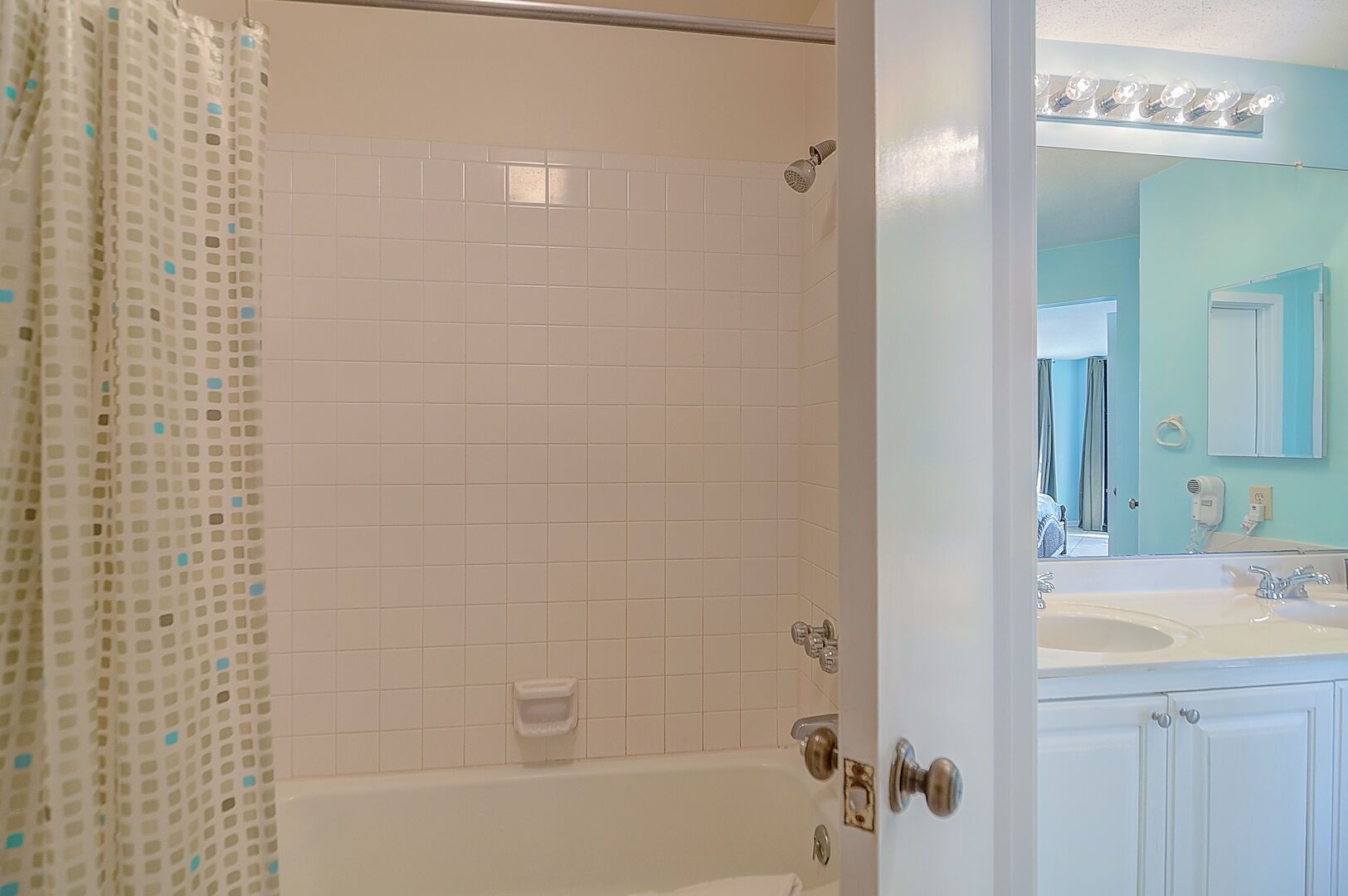 A bathroom with a shower, a sink, and a mirror.