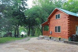 A rustic log cabin with a porch, surrounded by a forest. - Cozy Authentic Amish Cabin, 5 Acres Of Privacy, 4 Wheel Trail, Snowmobile Trail (Lampson)