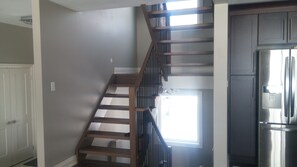 Enjoy cooking in this well-equipped kitchen with a refrigerator and staircase leading to an upper level.