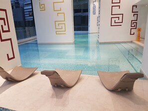 Relax by the pool with two lounge chairs overlooking the calm water.