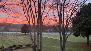 A rural landscape with a sunset, trees, and a fenced field. - Cozy Riverbend Retreat Horse & Pony Ranch, Pool & Patio • Private Trails • River (Hinckley)