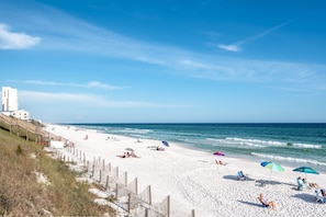 Guests can relax under umbrellas or stroll along the shore.
