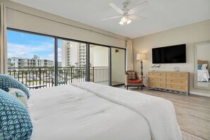 Relax in this spacious room with a large bed, flat-screen TV, and wicker dresser, plus a balcony with a view of the surrounding area.