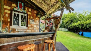 A rustic wooden bar with a thatched roof, a window, and a sign indicating a $500 charge for whinging. - A lakefront playground near beautiful Victoria on British Columbia's west coast. (victoria)