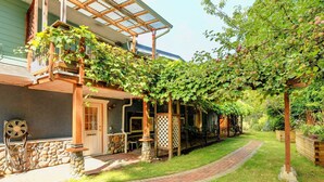 A covered outdoor area with a stone wall, a laundry sign, and a wooden pergola with vines. - A lakefront playground near beautiful Victoria on British Columbia's west coast. (victoria)