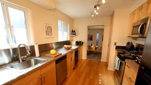 Una cocina moderna con armarios de madera, electrodomésticos de acero inoxidable y una isla central.