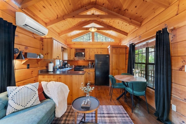A cabin interior with a kitchen, dining area, and living room.