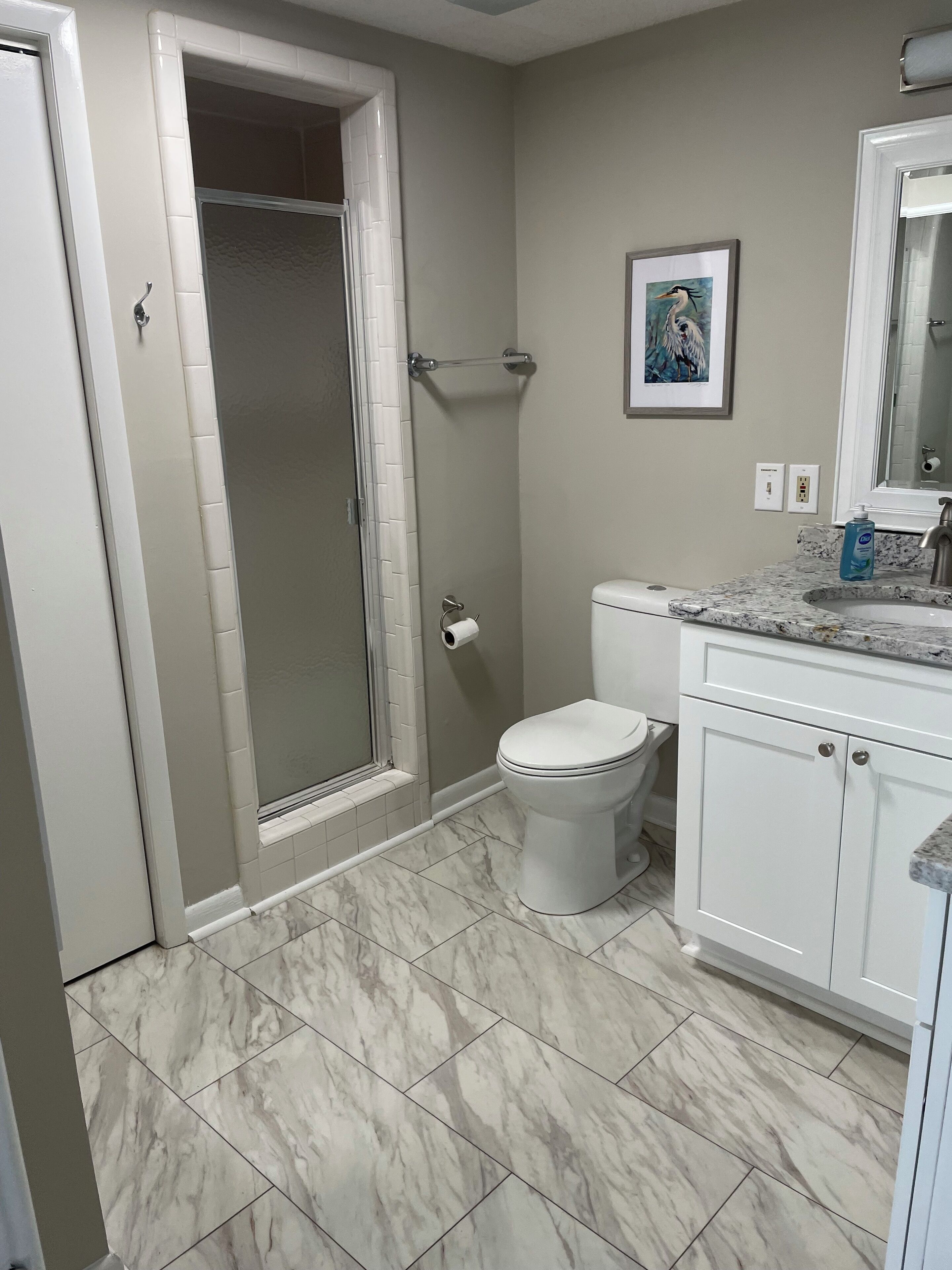 A bathroom with a shower, toilet, and sink.